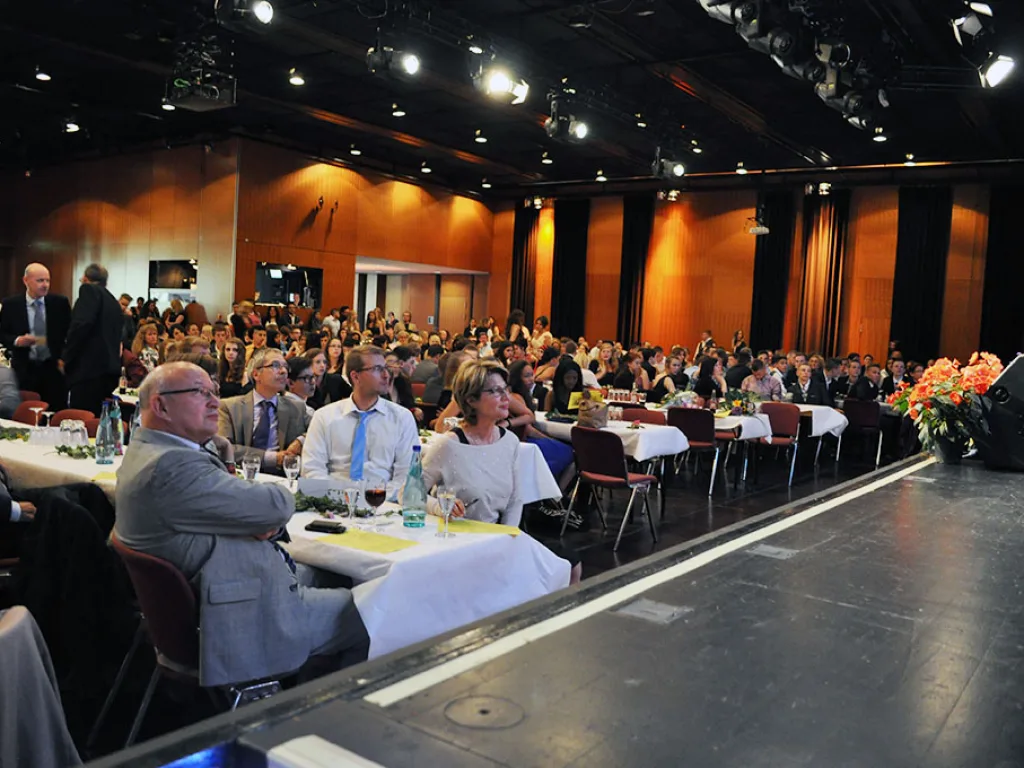 Gäste sitzen an den Tischen im Saal.